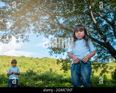 Der Konflikt der Schwestern bei Spielen im Garten. Geschwisterbeziehung. Probleme in den familiären Beziehungen zwischen Kindern. Stockfoto