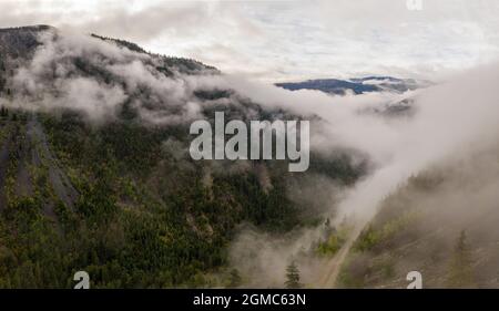 Luftpanorama der atemberaubenden Berglandschaft im Tweedsmuir (Süd) Provincial Park in einem dichten Nebel, der die umliegenden m bedeckt Stockfoto