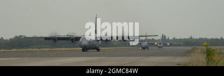 Zwei C-130J Super Hercules Flugzeuge vom Ramstein Air Base, Deutschland, und eine polnische Luftwaffe C-130E Hercules bereiten sich auf den Start in rascher Folge von einem verlassenen Flugplatz in der Nähe von Biala Podlaska, Polen, während der Aviation Detachment Rotation vor 21.4, Sept. 16, 2021. Die Anwendung des Konzepts der agilen Kampfbeschäftigung mit solchen Operationen soll sicherstellen, dass die US Air Forces Europe – Air Forces Africa Forces für potenzielle Bedrohungen und Eventualitäten gerüstet sind, indem sie es den Truppen ermöglichen, Luftstrom schnell zu verteilen und weiterhin von Orten mit unterschiedlichen Kapazitätsniveaus zu liefern Und Support. Stockfoto