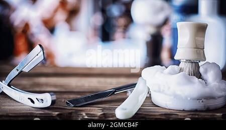 Rasierzubehör auf einem Hintergrund mit Holzstruktur. Werkzeuge. Einweg-Rasierer, Bürste, Rasierer mit Schaumgefahr. Stockfoto