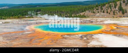 Grand Prismatic Spring Panorama mit Touristen, die im Sommer auf einem erhöhten Gehweg spazieren, Yellowstone Nationalpark, Wyoming, USA. Stockfoto