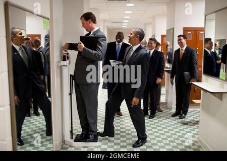 Präsident Barack Obama legt sich auf die Waage, als Trip Director Marvin Nicholson versucht, sich während eines Laderaums in der Volleyball-Umkleidekabine der University of Texas in Austin, Texas, am 9. August 2010, zu wiegen. (Offizielles Foto des Weißen Hauses von Pete Souza)Dieses offizielle Foto des Weißen Hauses wird nur zur Veröffentlichung durch Nachrichtenorganisationen und/oder zum persönlichen Druck durch die Betreffzeile(en) des Fotos zur Verfügung gestellt. Das Foto darf in keiner Weise manipuliert werden und darf nicht in kommerziellen oder politischen Materialien, Werbung, E-Mails, Produkten oder Werbeaktionen verwendet werden, die in irgendeiner Weise andeuten Stockfoto