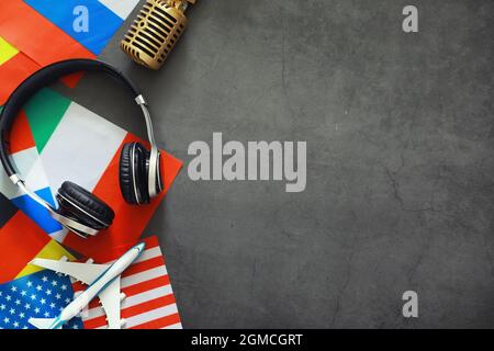 Fremdsprachen lernen. Audio-Sprachkurse. Hintergrund von Länderflaggen und Kopfhörern auf dem Tisch. Stockfoto