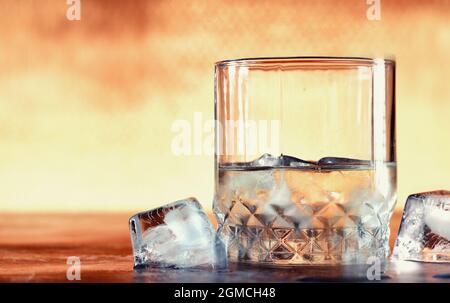 Ein Glas harten Alkohols mit Eis auf einer Theke. Whiskey mit Soda im Glas. Werbung für alkoholische Getränke. Stockfoto