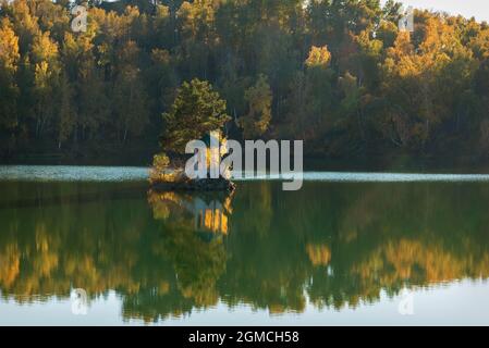 Herrlicher Herbstblick mit einem wunderschönen Pavillon auf einer Insel inmitten eines Bergsees, goldenen Bäumen am Hang und Spiegelreflexen im Wat Stockfoto