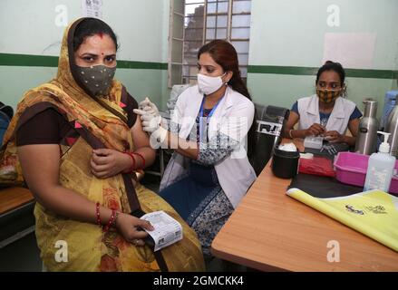 Rajasthan, Indien. September 2021. Beawar, Rajasthan, Indien, 17. September 2021: Gesundheitshelfer impft während der Mega-Impfkampagne zum 71. Geburtstag von Premierminister Narendra Modi in Beawar eine COVID-19-Impfdosis an eine Frau in der städtischen Apotheke. Indien hat am 17. September an einem einzigen Tag einen Weltrekord mit mehr als 2.50 crore COVID-Impfstoffdosen aufgestellt. Foto: Sumit Swarwat Kredit: Sumit Swarwat/Alamy Live News Stockfoto