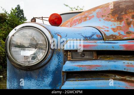 Der Scheinwerfer und der Grill auf einem rostblauen antiken Lastwagen Stockfoto