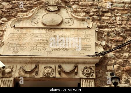 Galata, Karaköy-Viertel von Istanbul, Türkei. Haupteingang des Galata-Turms, geschmückt mit Wappenreliefs und arabischen Inschriften. Stockfoto