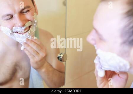 Ein Mann rasiert morgens vor der Arbeit im Bad Stockfoto