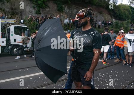 Melbourne, Australien. September 2021. Ein Anti-Lockdown-Protestler, der einen Regenschirm und eine Schutzbrille verwendet, nachdem er von der Polizei mit Pfeffer besprüht wurde. Quelle: Jay Kogler/Alamy Live News Stockfoto