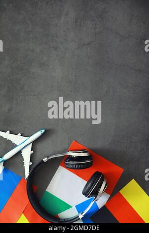 Fremdsprachen lernen. Audio-Sprachkurse. Hintergrund von Länderflaggen und Kopfhörern auf dem Tisch. Stockfoto