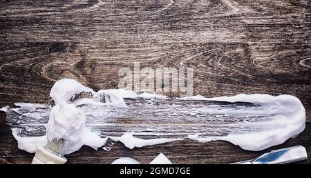 Rasierzubehör auf einem Hintergrund mit Holzstruktur. Werkzeuge. Einweg-Rasierer, Bürste, Rasierer mit Schaumgefahr. Stockfoto