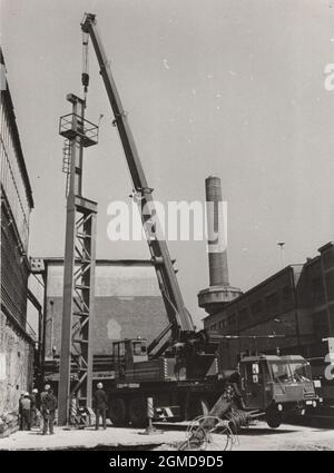 Original monochromes Foto aus den 1970er Jahren, wo ein Lokomo Ein 351 NS Mobilkran ein massives etwas auf einer Baustelle wieder hochhob. Stockfoto