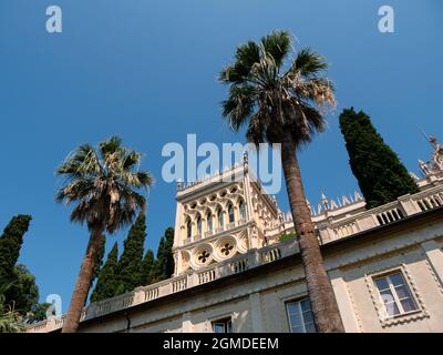 Villa Borghese auf der Insel Isola del Garda, ein Palast in einer Fassade im venezianischen neugotischen Stil mit Palmen Stockfoto