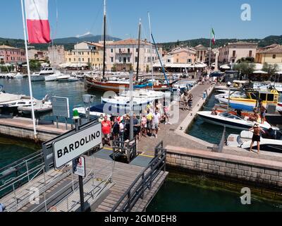 Bardolino, Venetien, Italien - August 09 2021: Hafenfähre Festmachen am Gardasee im Sommer mit Touristen Stockfoto