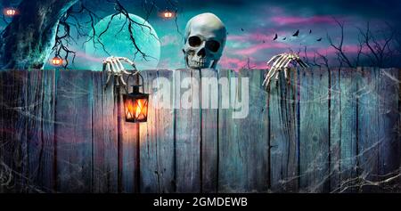 Halloween - Skelett Hält Laterne Auf Holzbanner In Der Nacht Stockfoto