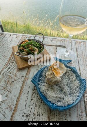 Austern werden in einem Restaurant in Aveiro neben den Salzwiesen in Portugal serviert. Stockfoto