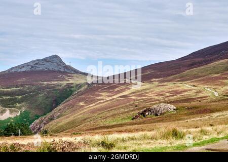 Der Wales Coast Path führt durch offene Heide zwischen den Zwillingsgipfeln von Yr Eifl Stockfoto