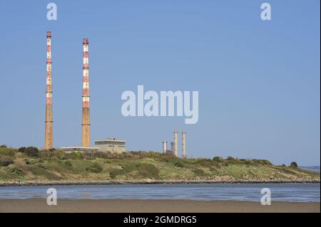 Nahaufnahme Heller Blick auf die berühmten Schornsteine des Poolbeg-Kraftwerks und die CCGT-Station Poolbeg vor dem klaren blauen Himmel vom Sandymount Beach in Dublin aus Stockfoto