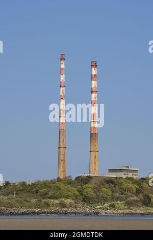 Schöne Nahaufnahme vertikale helle Ansicht der ikonischen Poolbeg CCGT Station Kamine vor klarem blauen Himmel vom Sandymount Beach, Dublin, Irland. Sof Stockfoto