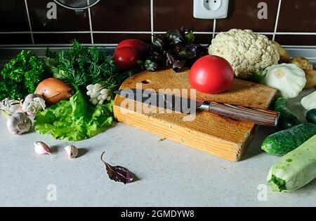 Stillleben von frischem Gemüse und Kräutern auf dem Küchentisch. Stockfoto