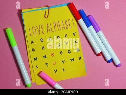Romantik, Liebe und valentinstag-Konzept. Draufsicht auf farbigem Notizbuch mit Text LOVE ALPHABET I LOVE U, umgeben von farbigem Stift Stockfoto