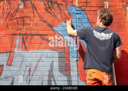 Birmingham, Großbritannien. September 2021. Ein Graffiti-Künstler bei der Arbeit während des High Vis Street Culture Festivals, das am Wochenende in Digbeth, Birmingham, stattfindet. Der Stadtteil Digbeth der Stadt ist bekannt für seine Street Graffiti-Kultur. Kredit: Peter Lopeman/Alamy Live Nachrichten Stockfoto