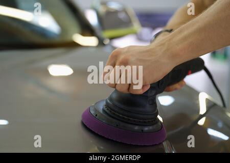 Männliche Hände Polieren Haube des Autos mit speziellen Maschine Nahaufnahme Stockfoto