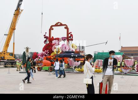 Peking, China. September 2021. Touristen gehen in der Nähe des Blumenbeete mit dem Thema "segne das Mutterland" auf dem Platz des Himmlischen Friedens in Peking. Am 1. Oktober dieses Jahres, dem Nationalfeiertag der Volksrepublik China, wird ein Blumenbeet mit dem Thema „das Mutterland segnen“ im Zentrum des Tiananmen-Platzes aufgestellt. Die Oberseite des Blumenbeete ist 18 Meter hoch, mit einem festlichen Blumenkorb als Hauptszene. Kredit: SOPA Images Limited/Alamy Live Nachrichten Stockfoto