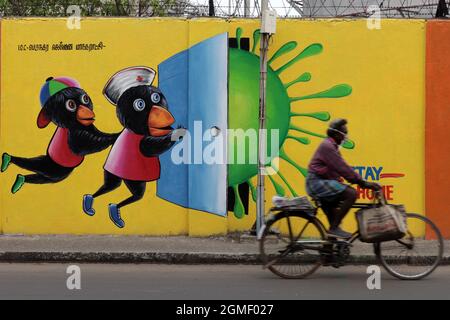 Chennai, Tamil Nadu, Indien. September 2021. Ein Mann fährt mit dem Fahrrad an einem Covid-19 Coronavirus-Bewusstseinsbild entlang des Straßenrands in Chennai vorbei. (Bild: © Sri Loganathan/ZUMA Press Wire) Stockfoto