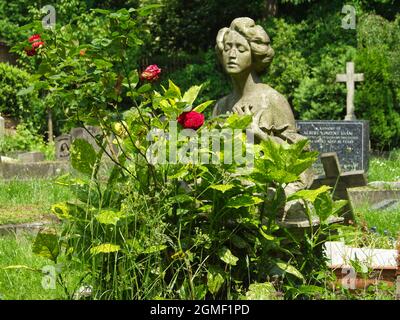 Statue einer jungen Frau auf einem Grab auf dem Londoner Highgate Friedhof. Stockfoto