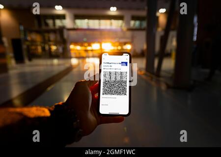 Ansicht einer Person, die ein Smartphone mit dem Digital Green Pass in einem Flughafenterminal hält. Reisekonzept während der Covid-19 Stockfoto