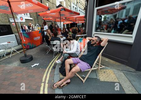 London, Großbritannien. 18. September 2021. Menschen in der Bar beim Bermondsey Street Festival, das nach der Absage im Jahr 2020 aufgrund von Covid-19-Bedenken zurückgekehrt ist. Die Veranstaltung gilt als Dorffäte in der Stadt mit Live-Aufführungen auf der Bühne, Ständen von lokalen Anbietern und einer Hundeschau. Kredit: Stephen Chung / Alamy Live Nachrichten Stockfoto