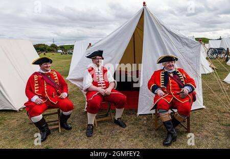 Prestonpans, East Lothian, Schottland, Großbritannien, 18. September 2021 Nachstellung der Schlacht von Prestonpans: Die Schlacht von Prestonpans im Jahr 1745 war eine der kürzesten Schlachten in der britischen Geschichte, aber es war ein vollständiger Sieg für Prinz Charles Edward Stuarts jakobitische Truppen gegen die hannoversche Armee unter der Führung von Sir John Cope. Im Bild: Die hannoverschen Offiziere mit Sir John Cope (ganz rechts) entspannen sich vor der Schlacht in zeitgemäß militärischem Kostüm Stockfoto