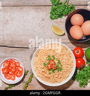 Instant Nudeln mit Gemüse isoliert auf Holztisch Stockfoto