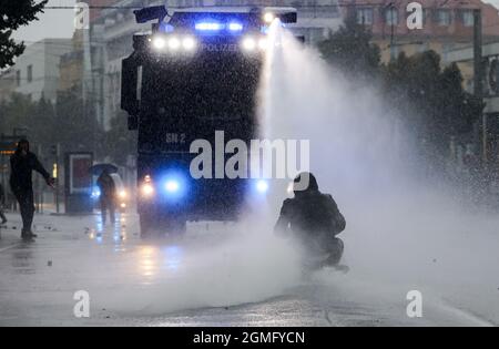 Leipzig, Deutschland. September 2021. Während der Unruhen sitzt ein linker Demonstrator vor einer Wasserkanone. Das Kampagnenbündnis 'Wir sind alle Linx' hatte bundesweit für die Demonstration mobilisiert. Quelle: Jan Woitas/dpa-Zentralbild/dpa/Alamy Live News Stockfoto