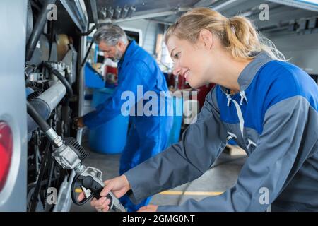 Schöne Frau Auto Mechaniker in blauen Overalls Stockfoto