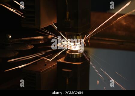 Funken durch automatisches Laserschneiden oder Gravieren von Teilen aus der Nähe Stockfoto