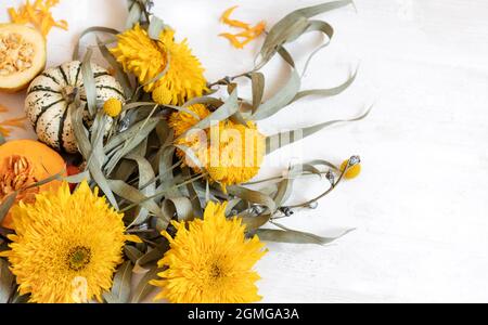 Festliches Herbstdekor aus Kürbissen und Blumen auf weißem Hintergrund, Kopierfläche. Konzept des Erntedankfestes oder Halloween. Stockfoto