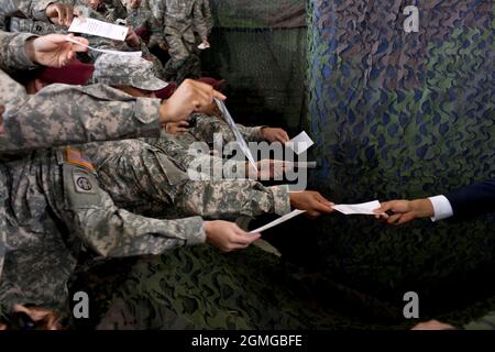 Präsident Barack Obama wird ein Blatt Papier zum Autogramm überreicht, nachdem er auf dem Pope Army Airfield, Fort Bragg, N.C., am 14. Dezember 2011 über das Ende des amerikanischen Krieges im Irak gesagt hatte. (Offizielles Foto des Weißen Hauses von Pete Souza) Dieses offizielle Foto des Weißen Hauses wird nur zur Veröffentlichung durch Nachrichtenorganisationen und/oder zum persönlichen Druck durch die Betreffzeile(en) des Fotos zur Verfügung gestellt. Das Foto darf in keiner Weise manipuliert werden und darf nicht in kommerziellen oder politischen Materialien, Anzeigen, E-Mails, Produkten oder Werbeaktionen verwendet werden, die in irgendeiner Weise die Zustimmung oder Billigung des P nahelege Stockfoto