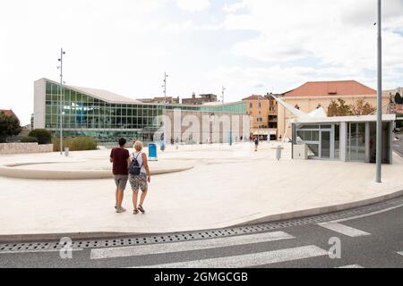 Sibenik, Kroatien - 25. August 2021: Stadtplatz vor der Altstadt, mit Stein und Glas öffentlichen Bibliotheksgebäude und Tiefgarage Eingang Stockfoto