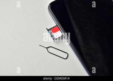 sim-Karte mit Smartphone und Auswurfstift auf weißem Hintergrund isoliert Stockfoto