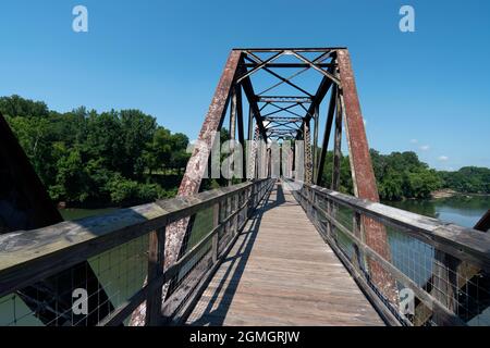 Alte Eisenbahnbrücke über den Fluss in der Sonne mit blauem Himmel Stockfoto
