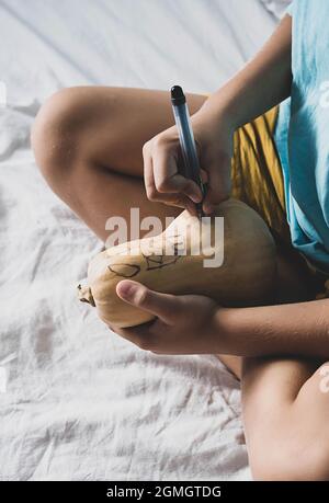 Junge, der Jack-o-Lantern zu Hause macht. Halloween DIY-Konzept. Stockfoto