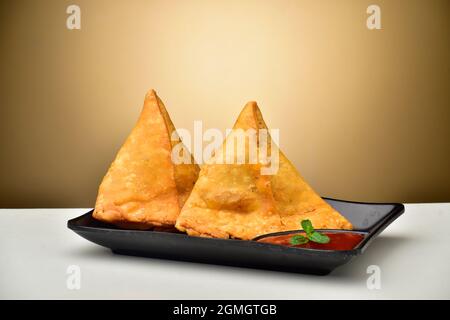 Gefüllte Samosa mit Sauce in Teller Stockfoto