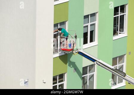 Nischni Nowgorod, Russland, Gagarin Avenue 101 b, Schule Nr. 34. 08.26.2021. Eine Frau, Angestellte einer Reinigungsfirma, wäscht die Fenster des Gebäudes Stockfoto