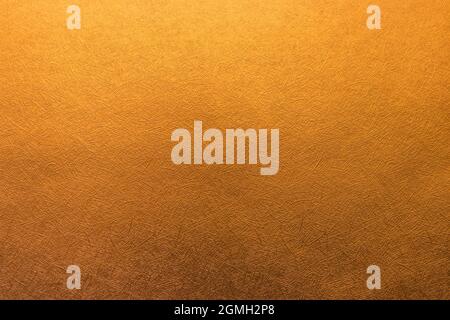 Weiche goldfarbene Hintergrundtextur, dezentes strukturiertes goldenes Papier Stockfoto