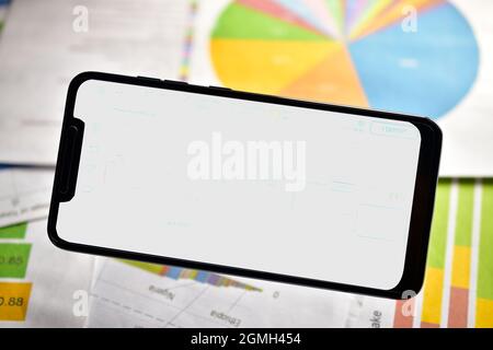 Leerer Bildschirm Smartphone auf Finanztabelle Stockfoto