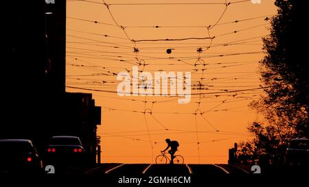 Silhouette bei Sonnenuntergang. Straßenbahnlinien in den Straßen der Stadt Melbourne Australien . Stockfoto