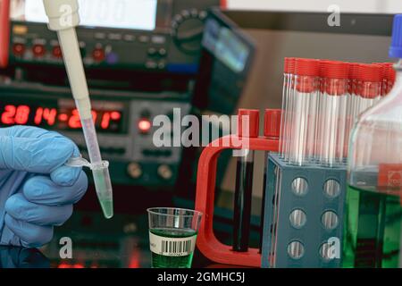 Probenvorbereitung für die Massenspektrometrie in einem wissenschaftlichen Labor. Füllen von Reagenzgläsern mit Proben mit einer Pipette und Messgeräten auf der b Stockfoto